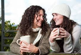 Mother and teen daughter talking over a cup of coffee